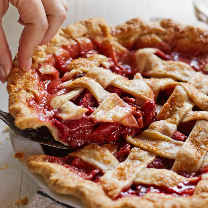 woman serving a strawberry rhubarb pie