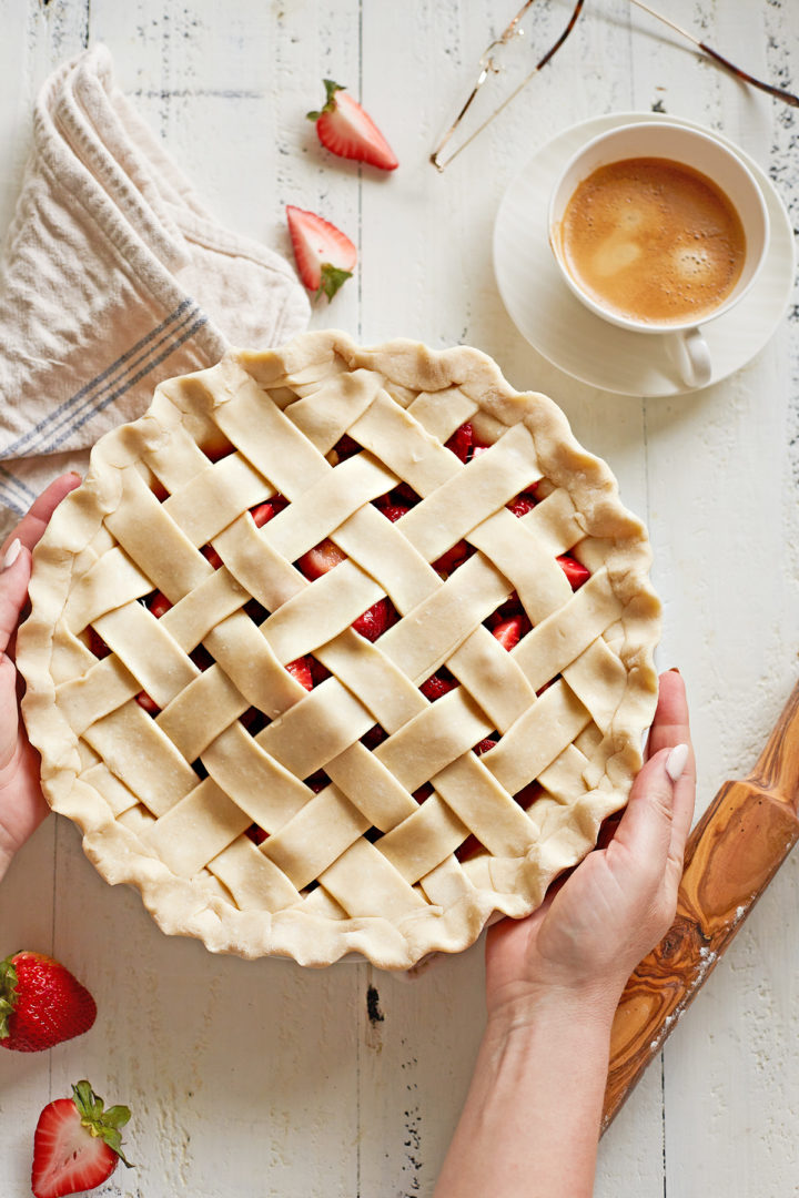 woman holding a pie plate with easy strawberry rhubarb pie recipe