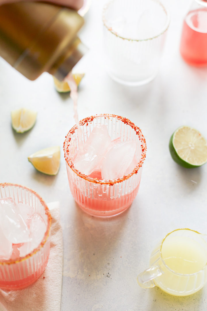 woman pouring fresh watermelon cocktails into glasses