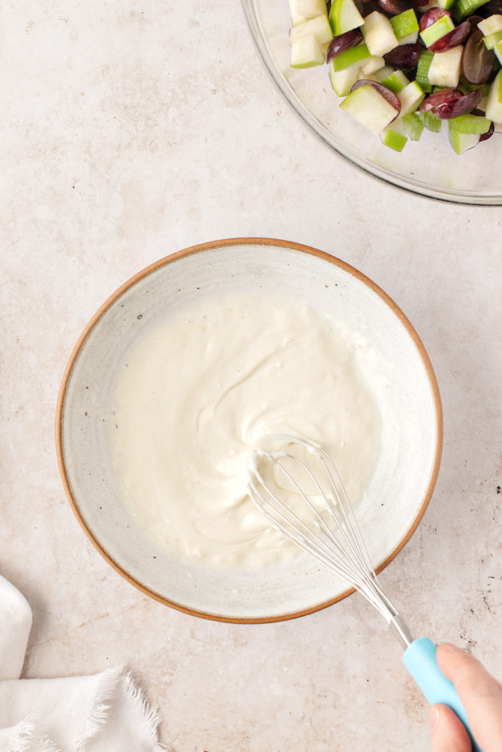 woman stirring Waldorf salad dressing