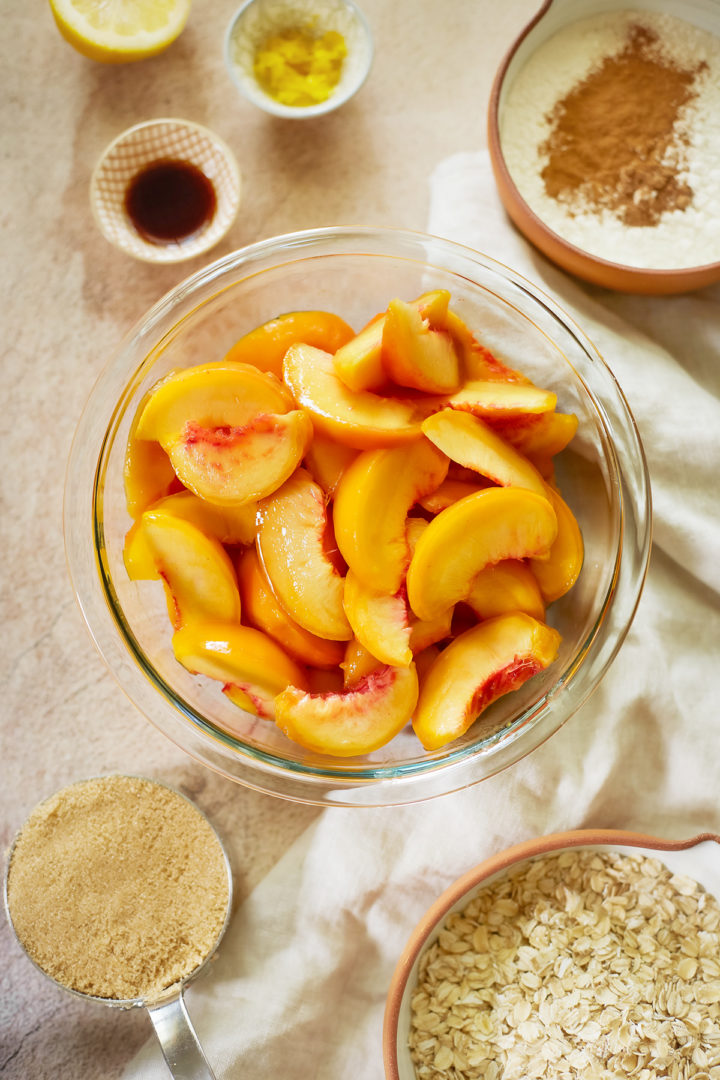 overhead photo of a bowl of peaches and other ingredients to make an easy peach crisp