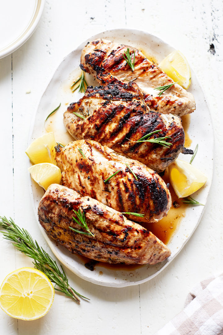 grilled lemon rosemary chicken on a white platter