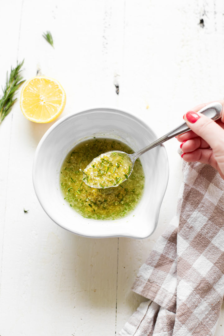 woman stirring a bowl of lemon rosemary marinade for chicken