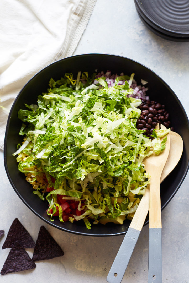 lettuce in a bowl with other veggie taco salad ingredients