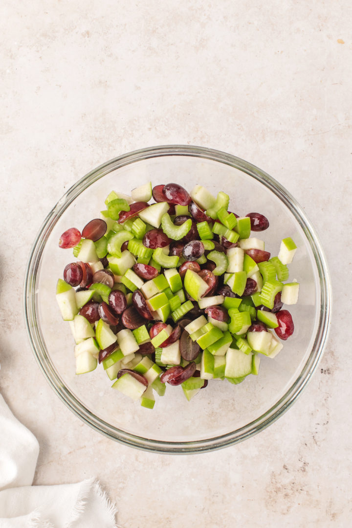 Waldorf fruit salad ingredients chopped in a glass bowl