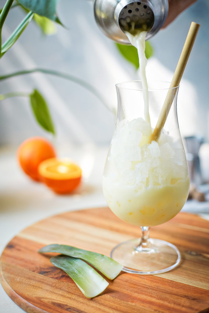 woman pouring a painkiller cocktail into a glass