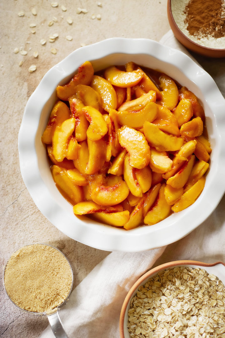 photo showing how to make recipe for peach crisp with oatmeal - a dish of fresh peaches with topping ingredients