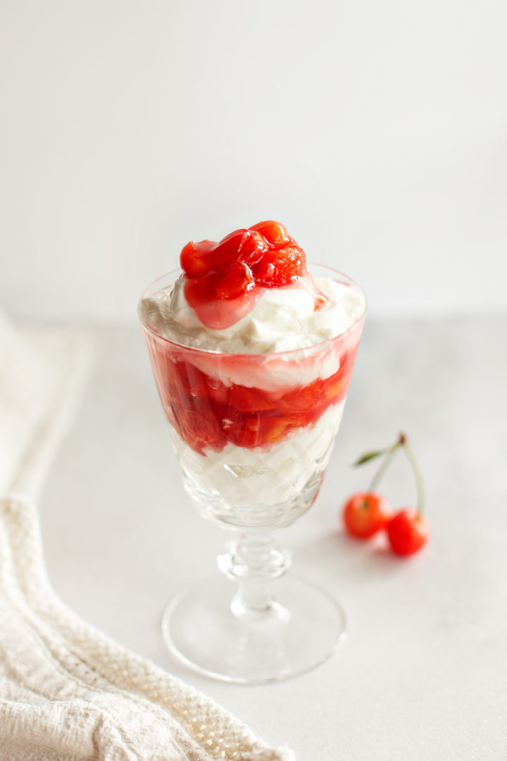 a crystal dessert glass with cherry pie filling and whipped cream