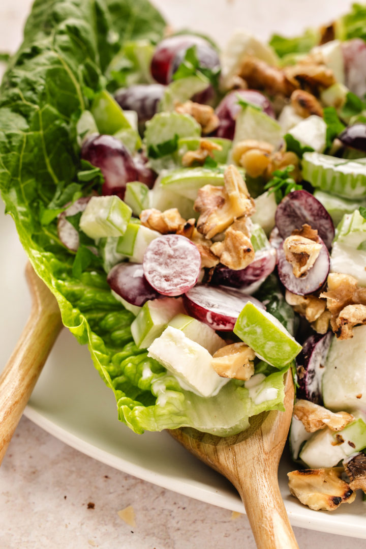 apple Waldorf salad being served with wooden spoons