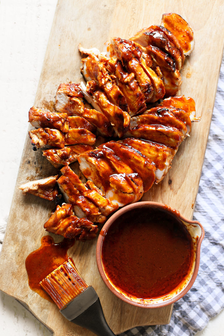 grilled bbq chicken sliced on a cutting board