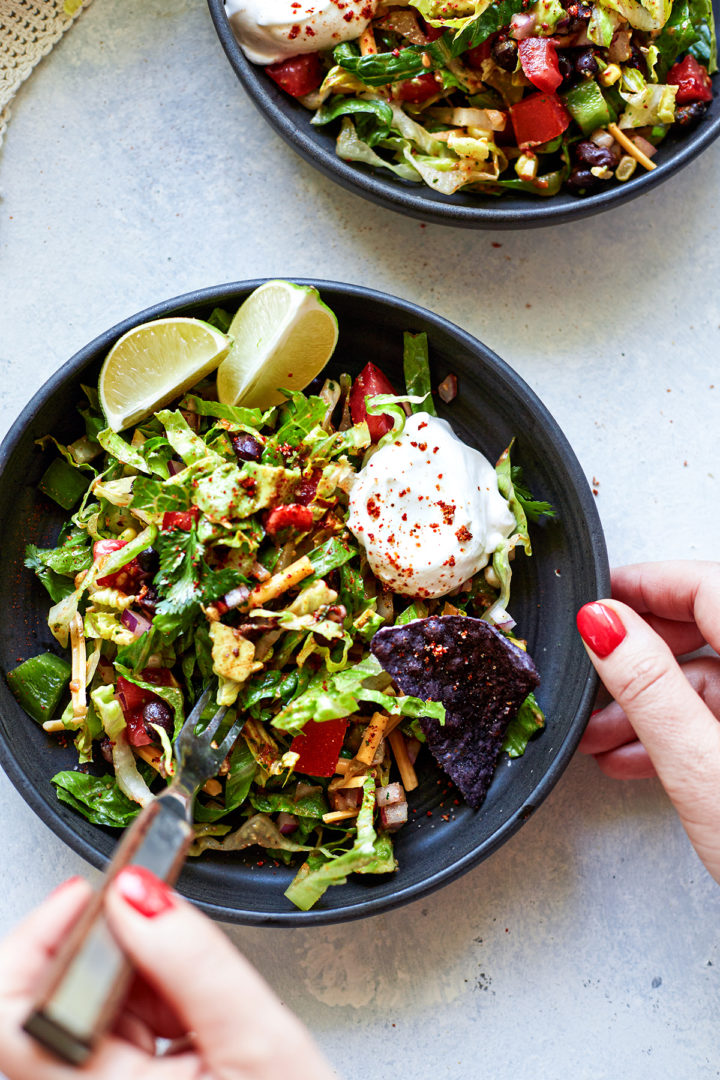 woman eating a plate of vegetarian taco salad