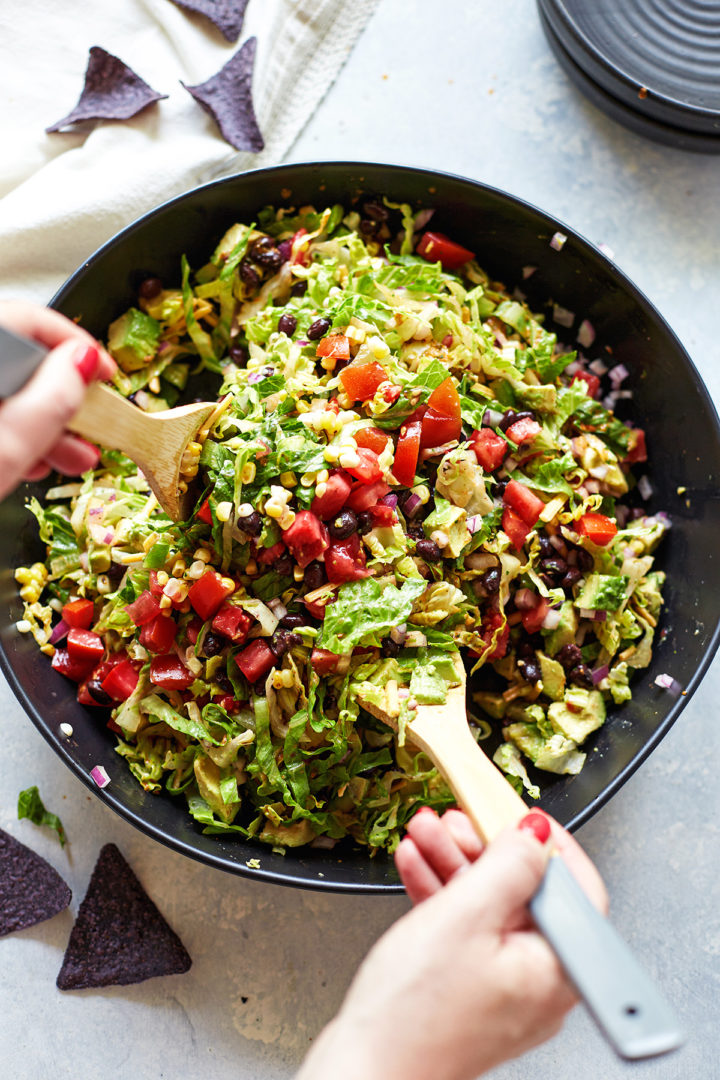 woman mixing taco salad with beans