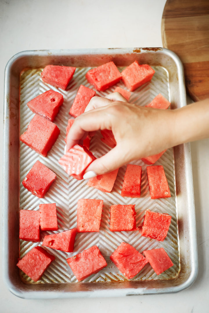 woman holding a piece of frozen watermelon