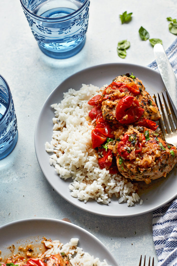 herbs de Provence chicken with grape tomatoes on a grey plate with silverware