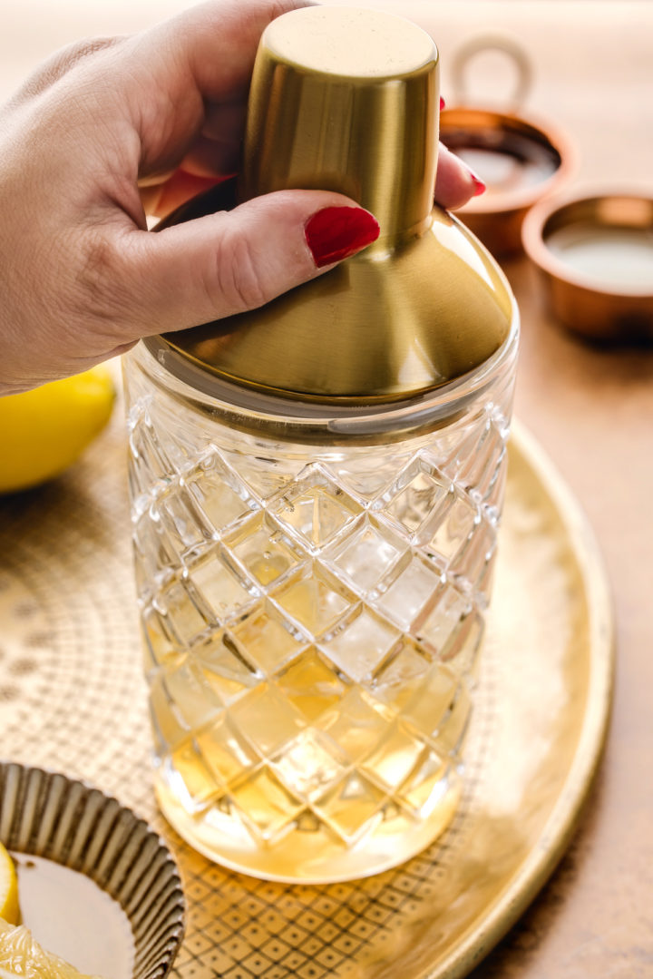 shaking the cocktail ingredients in a cocktail shaker with ice