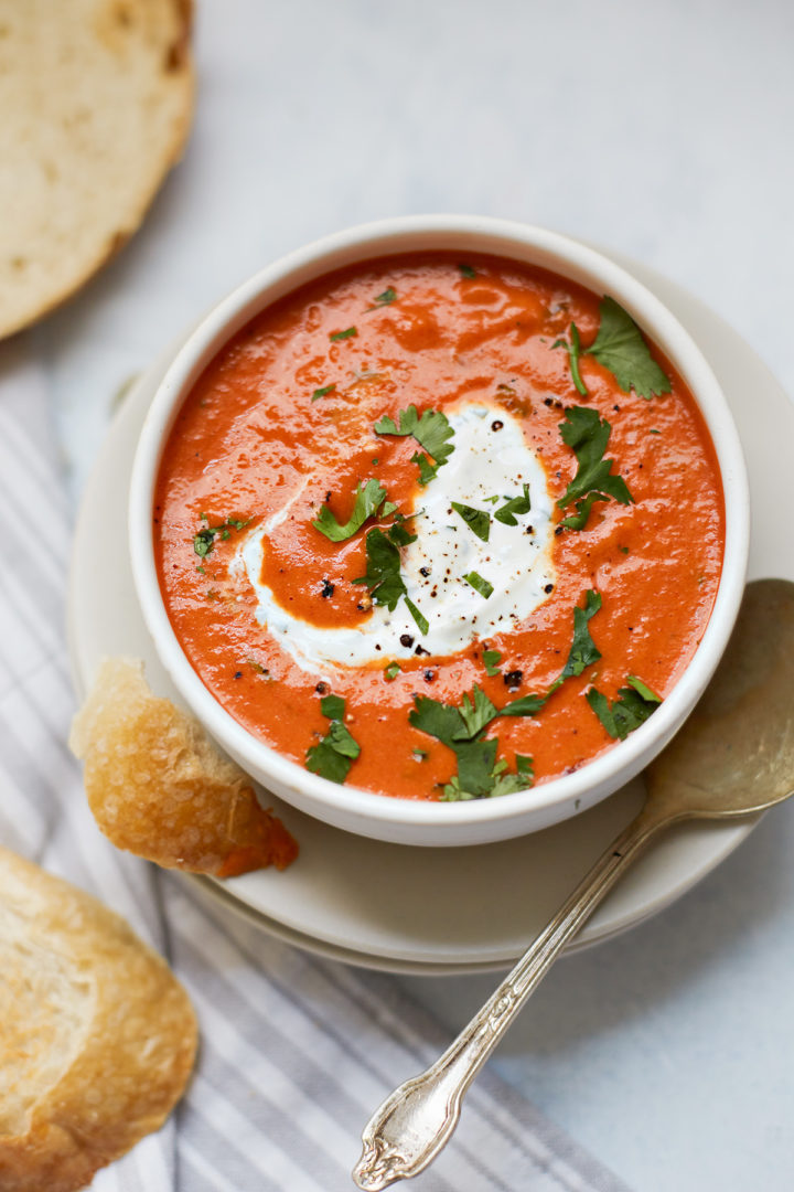 bowls of roasted red pepper soup swirled with cilantro cream