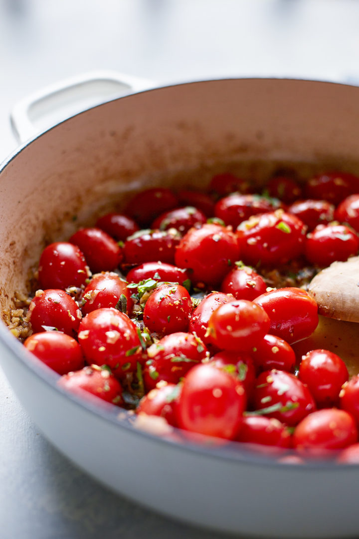 grape tomatoes cooking with garlic and herbs