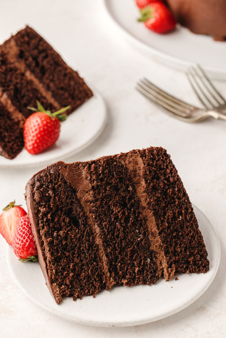 two slices of cake with chocolate ganache filling on white plates