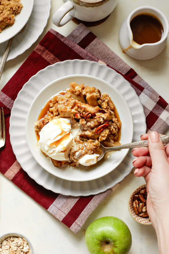 woman eating a bowl of caramel apple crisp with ice cream