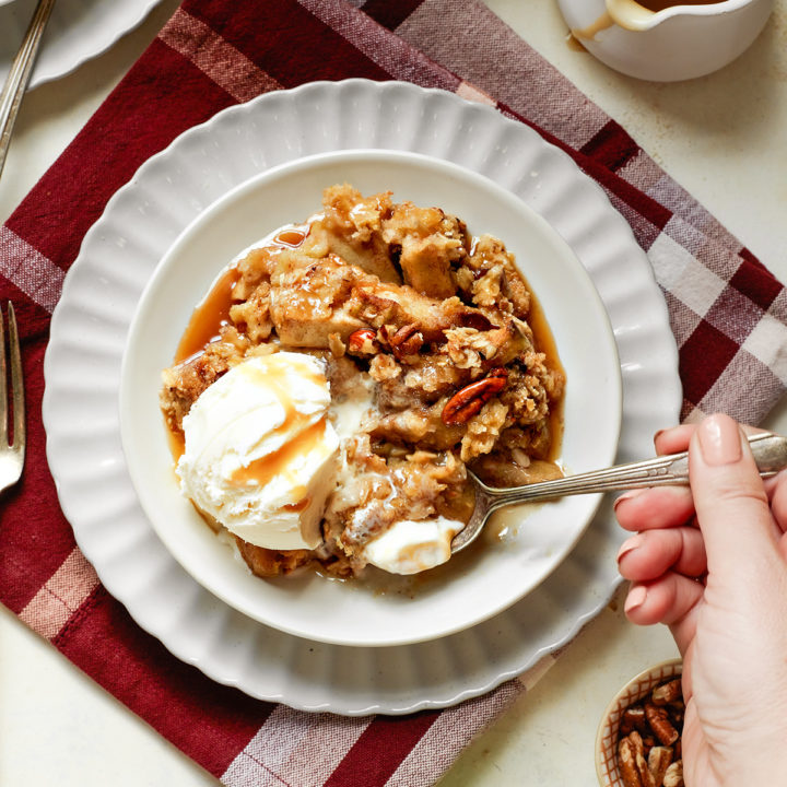 woman eating a bowl of caramel apple crisp with ice cream