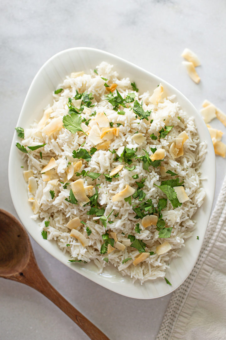 coconut jasmine rice in a serving bowl with a wooden spoon