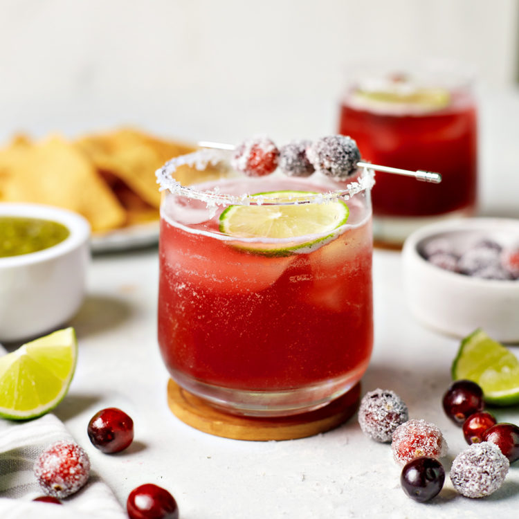 glasses of cranberry margaritas with lime and cranberry garnish