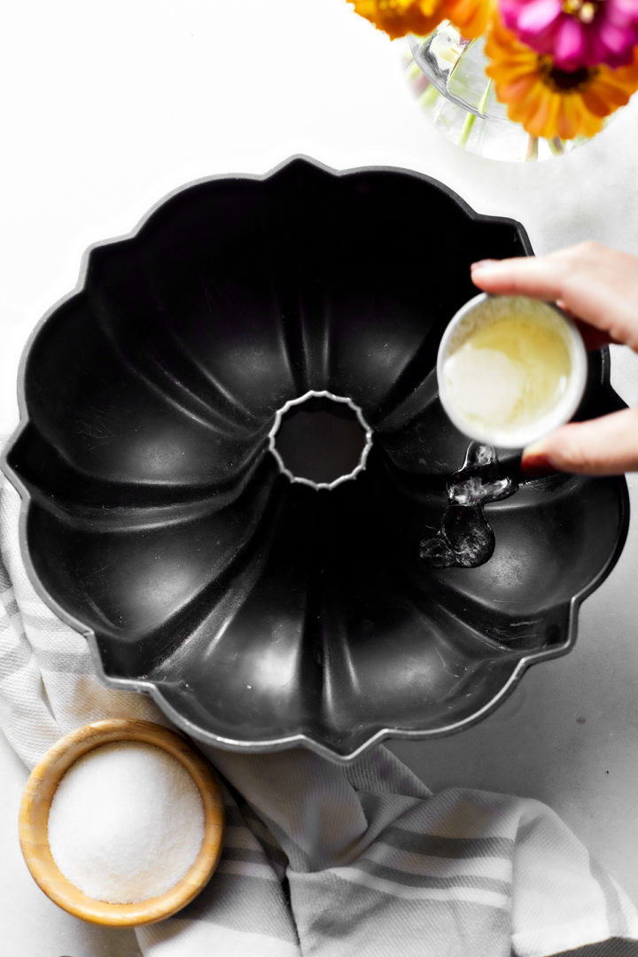 woman pouring melted shortening in a bundt pan