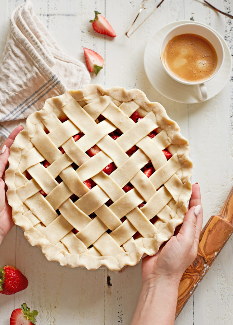 woman holding a pie with a lattice pie crust