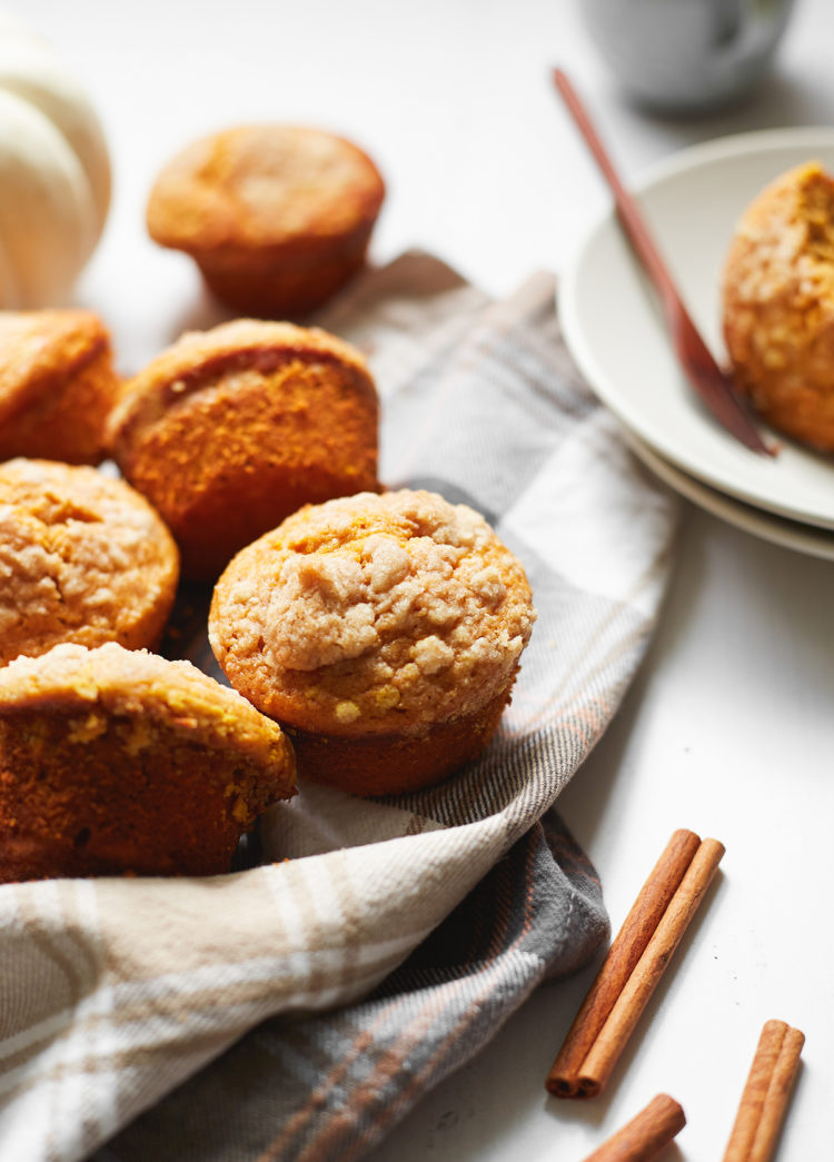 a batch of high protein pumpkin muffins on a plaid dish towel