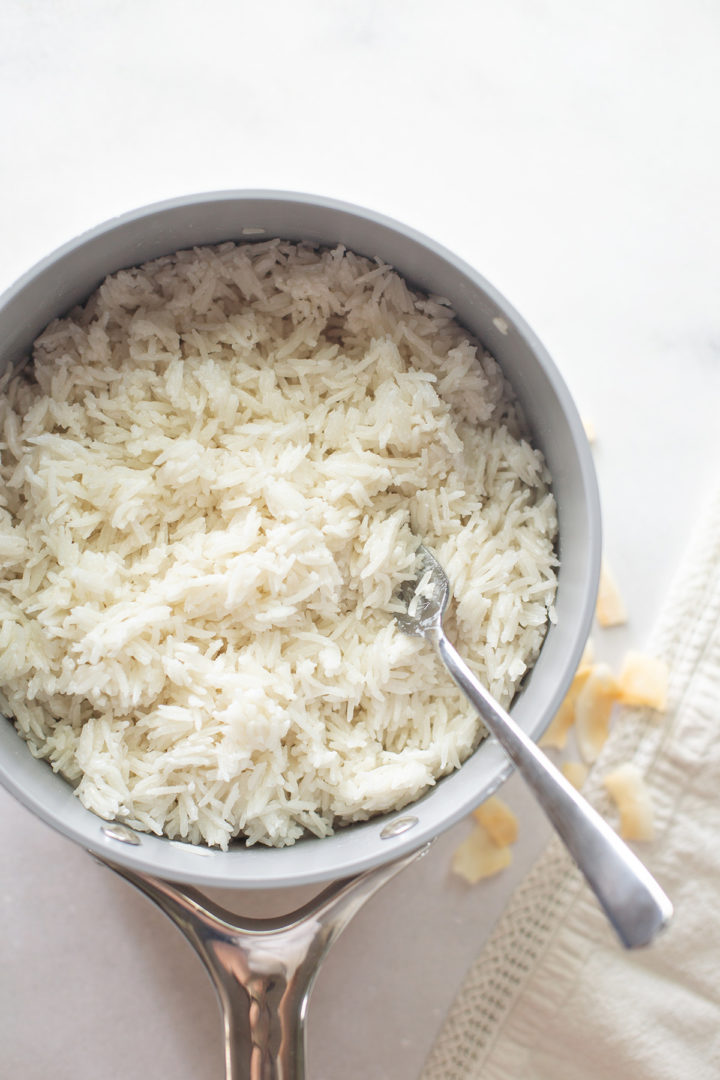 a pan of coconut milk rice in a pan with a fork