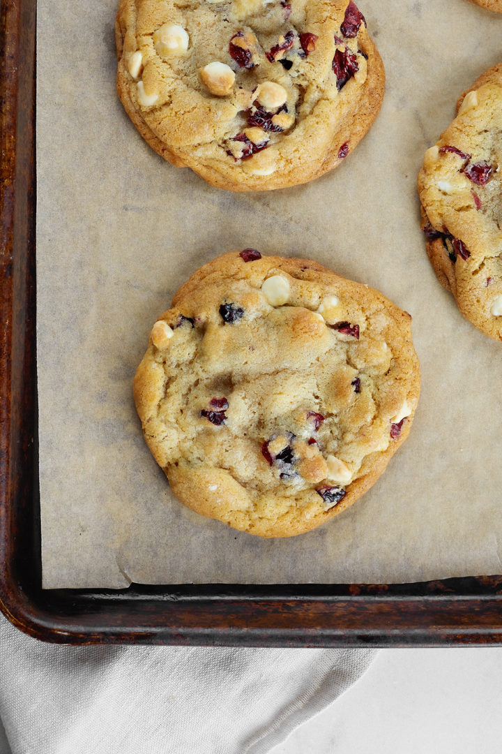 white chocolate and dried cranberry cookies on a baking sheet