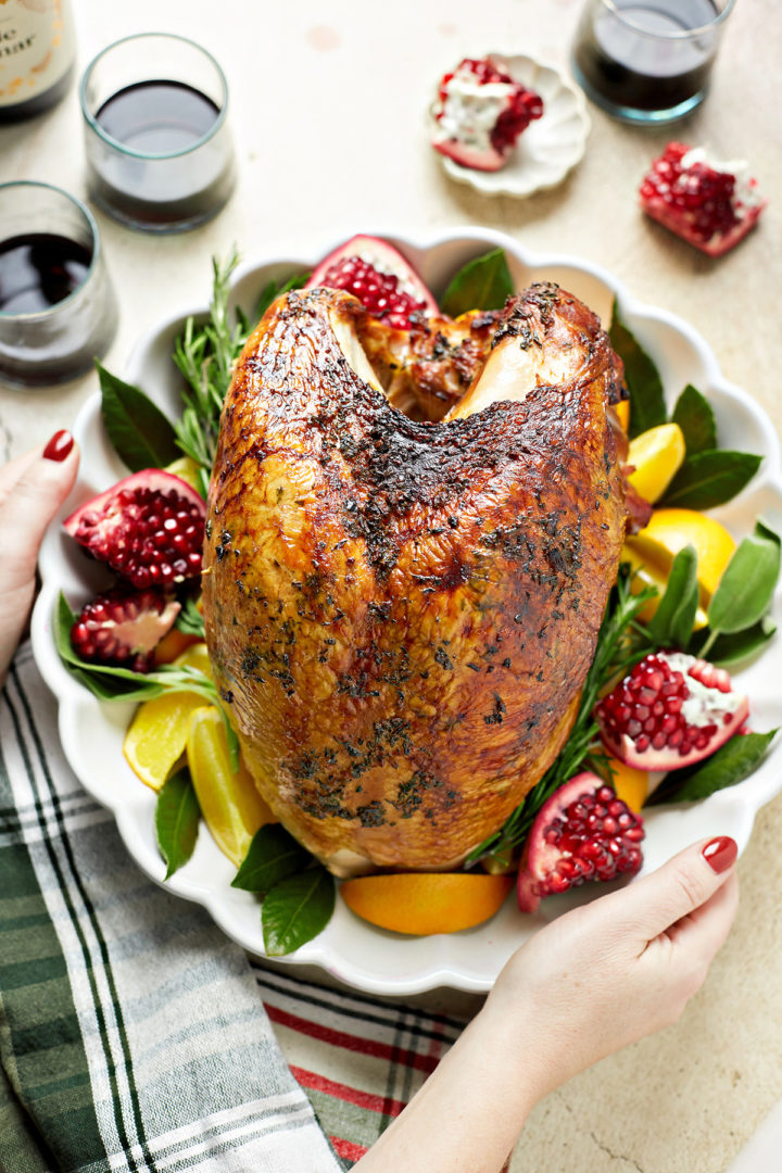 woman setting a platter of smoked turkey breast on the table