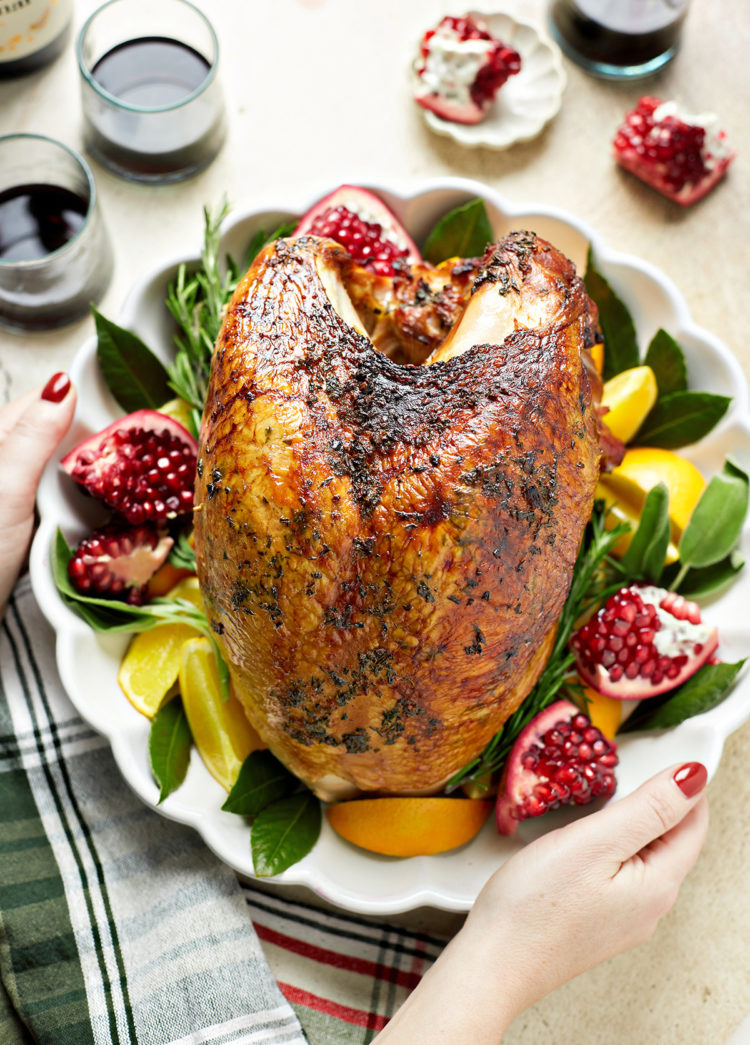 woman setting a platter of smoked turkey breast on the table