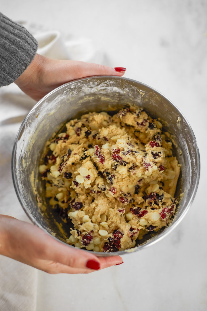 woman holding a bowl of cookie dough for a cranberry white chocolate cookie recipe