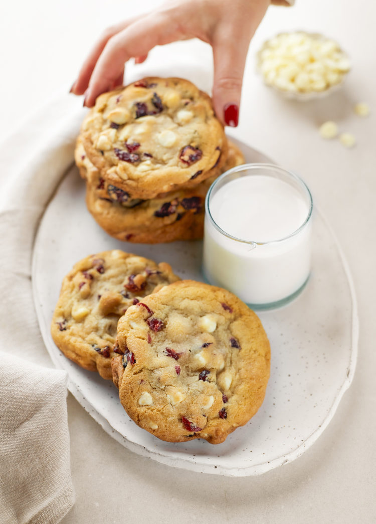 woman picking up a cranberry white chocolate cookie