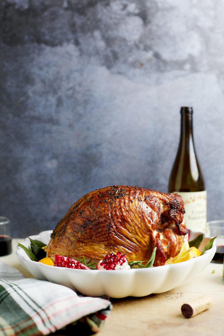 smoked turkey breast on the table next to a bottle of wine