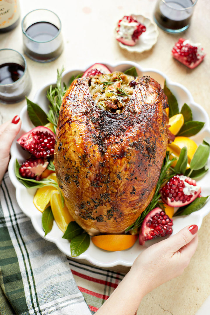 woman holding a stuffed turkey on a serving platter