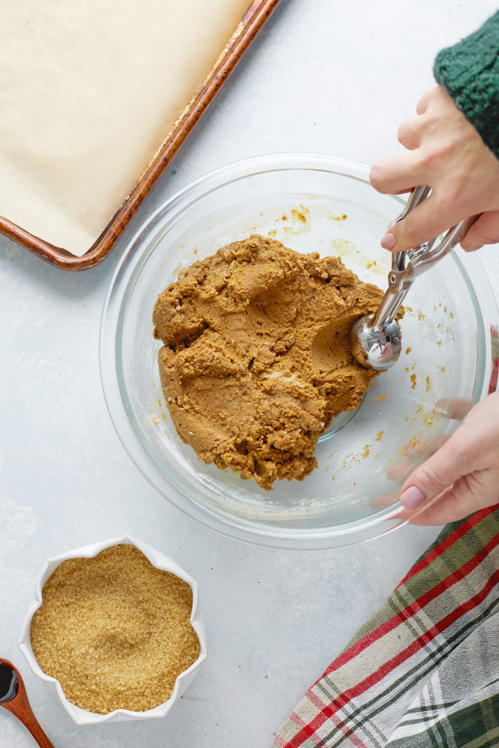 woman scooping dough for gingersnap cookies