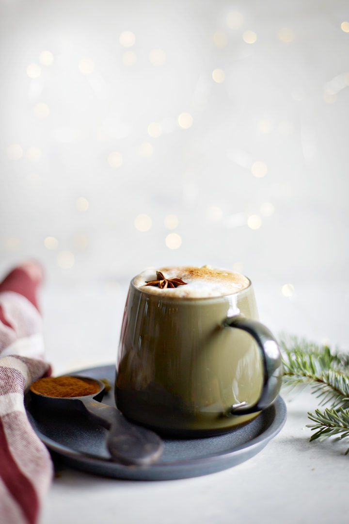 mug of gingerbread chai latte surrounded by white christmas lights