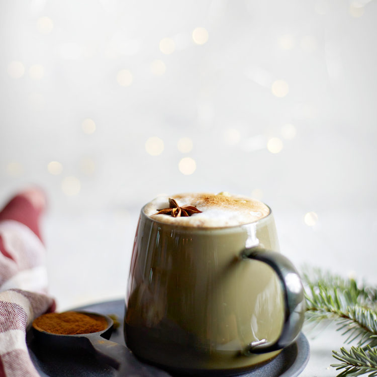 mug of gingerbread chai latte surrounded by white christmas lights