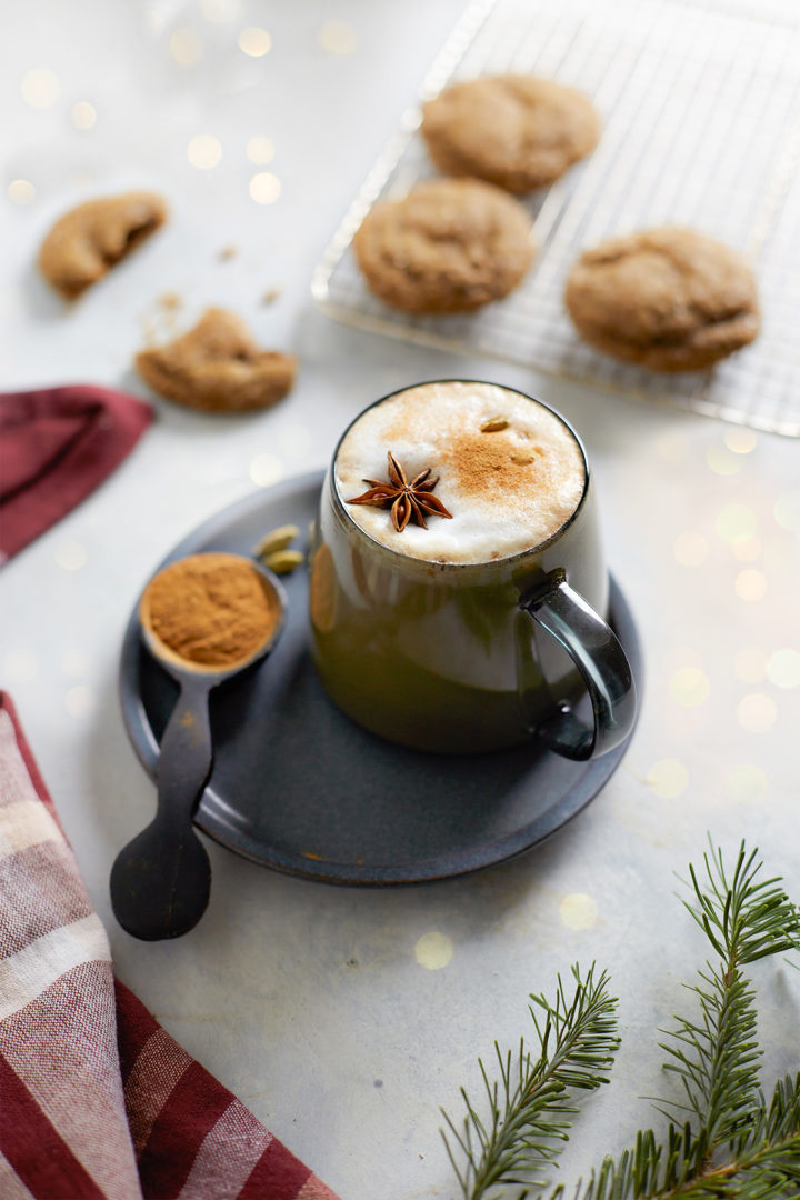 mug of gingerbread chai latte on a plate with cookies