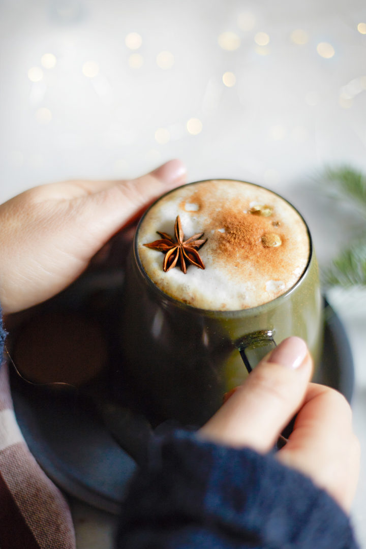 woman holding a mug of gingerbread chai latte