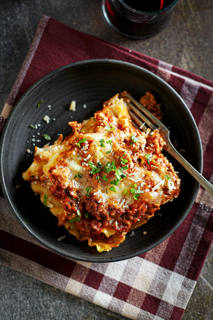 a slice of ground turkey lasagna on a black plate