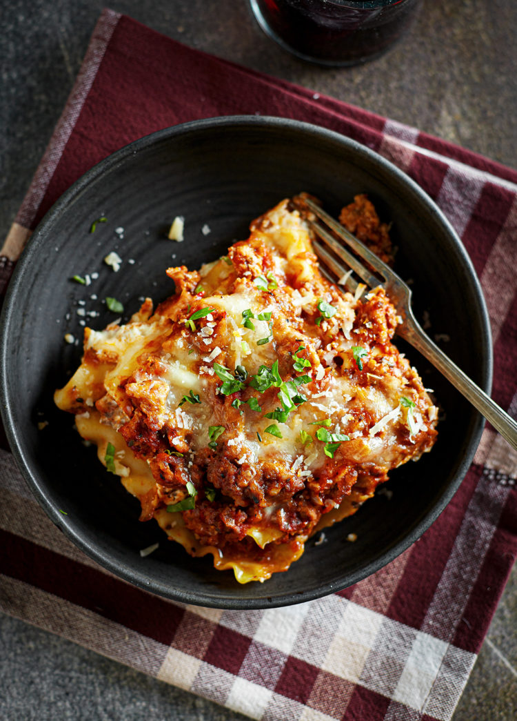 a slice of ground turkey lasagna on a black plate