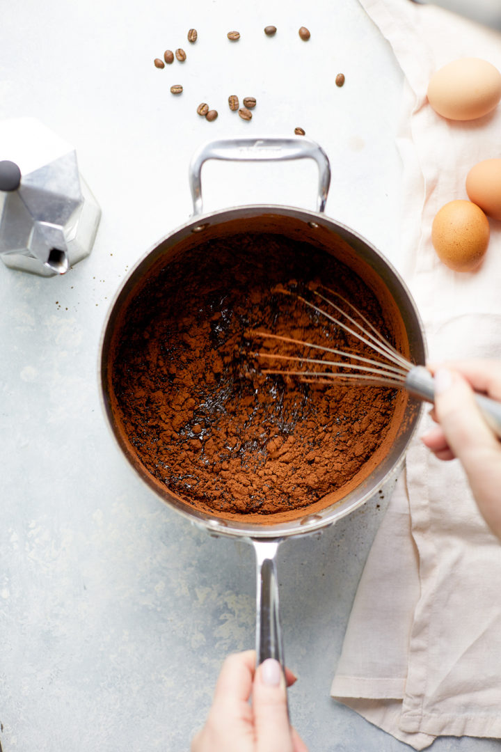 woman stirring cocoa powder into brownie batter